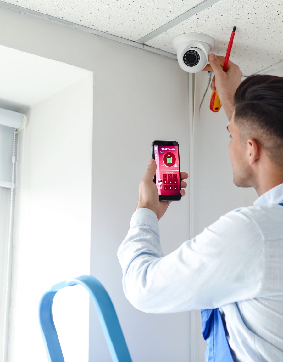 An FMB Install technician fitting a device to a ceiling